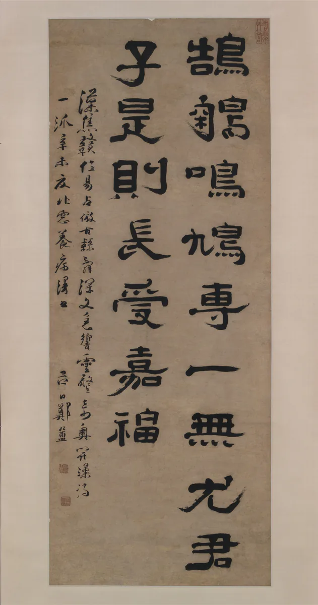 A tall hanging scroll with columns of broad, heavy clerical-script characters in black ink.